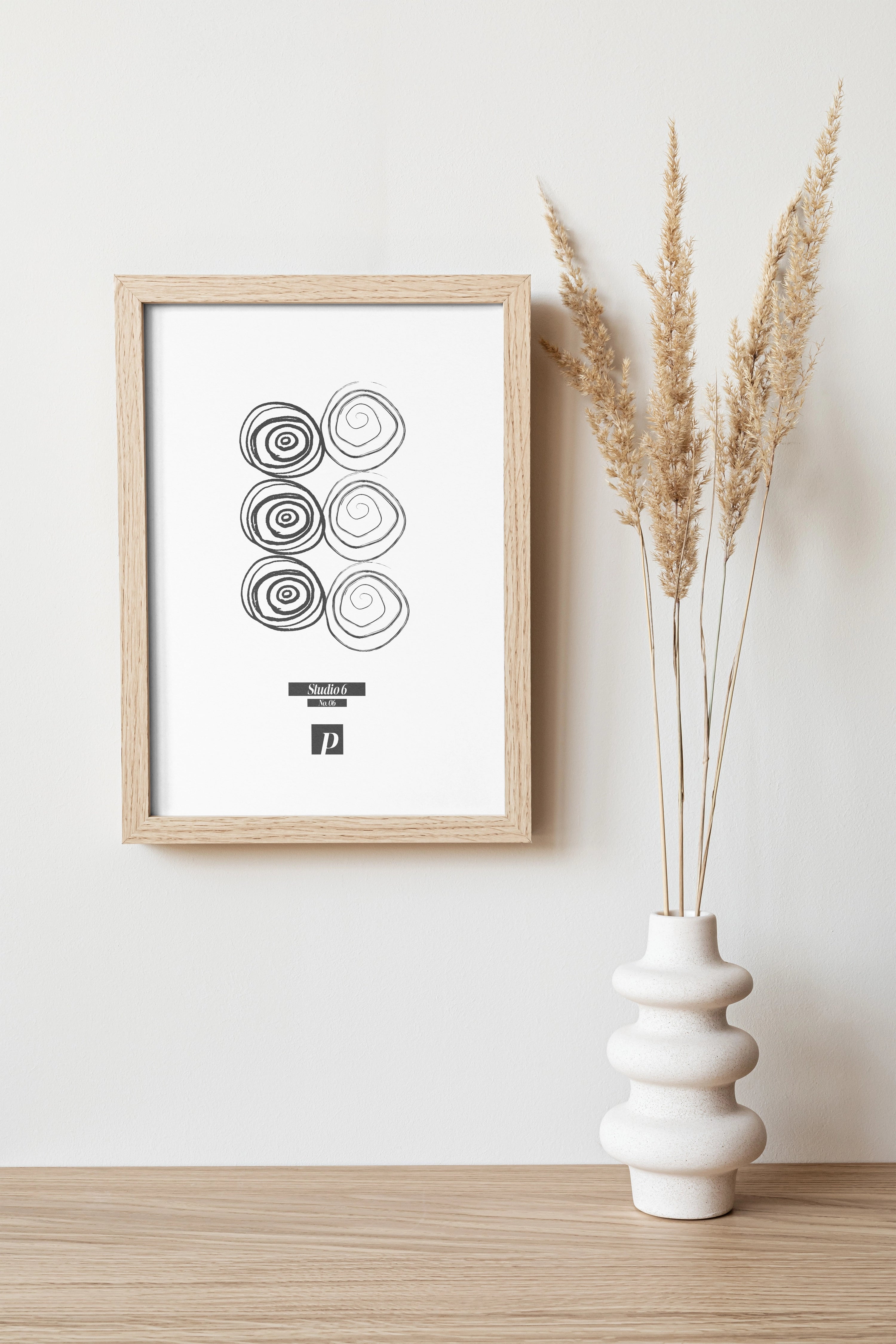 Minimalistisches Poster im Holzrahmen mit abstrakten Kreisen, dekorativ auf Sideboard neben Keramikvase im modernen Wohnzimmer